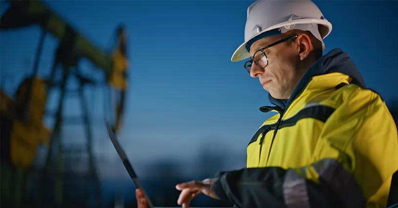 Construction worker looking at a laptop.
